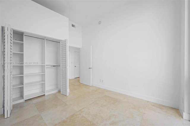 unfurnished bedroom featuring baseboards, visible vents, and a closet