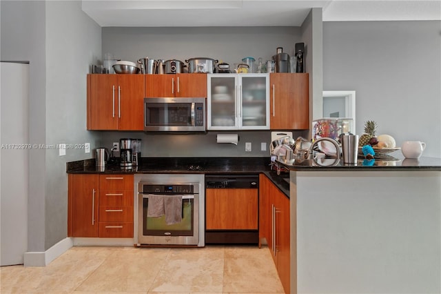 kitchen with dark stone countertops, light tile patterned floors, and stainless steel appliances