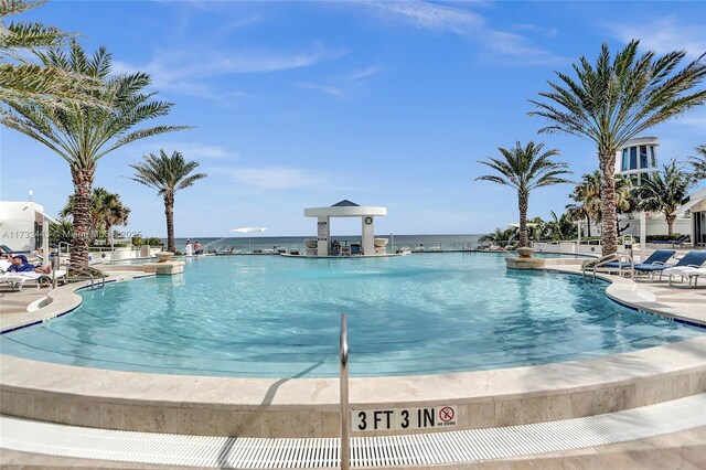 view of swimming pool featuring a water view and a patio area