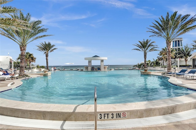 view of pool with a water view and a patio area