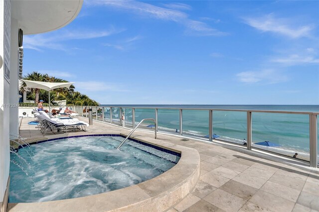 view of pool with an in ground hot tub and a water view