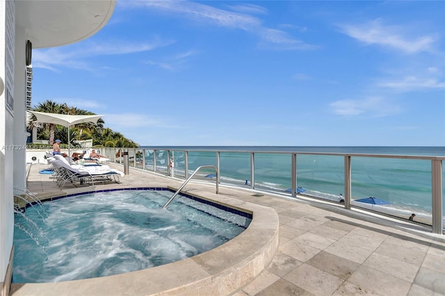 view of swimming pool with an in ground hot tub and a water view