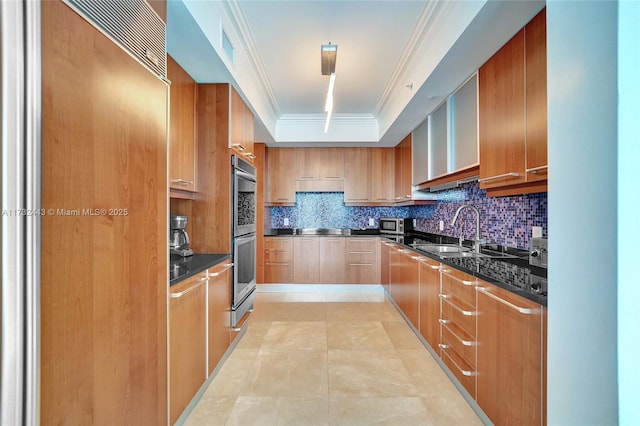 kitchen featuring sink, tasteful backsplash, a raised ceiling, crown molding, and double oven