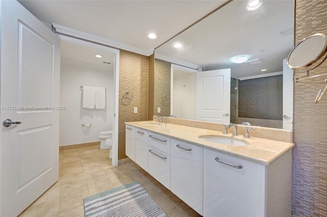 bathroom featuring vanity, crown molding, tile patterned flooring, and toilet