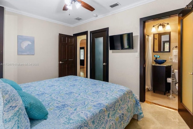 bedroom with ornamental molding, ensuite bathroom, and ceiling fan