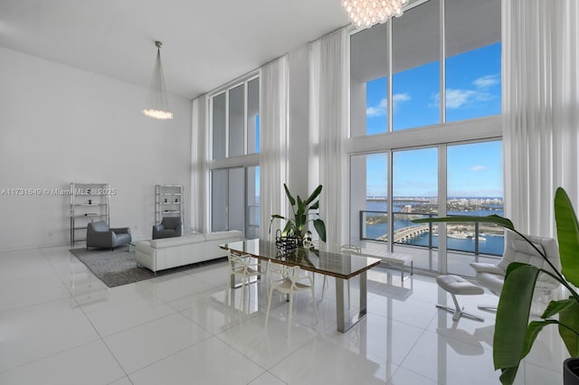 interior space with an inviting chandelier, a towering ceiling, and a water view