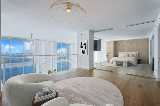 bedroom with hardwood / wood-style flooring and expansive windows