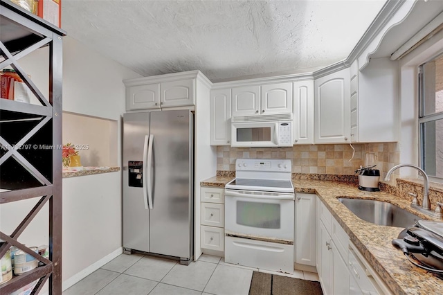 kitchen with white cabinetry, white appliances, light tile patterned flooring, and sink