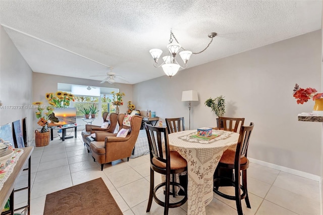 tiled dining area featuring ceiling fan with notable chandelier and a textured ceiling