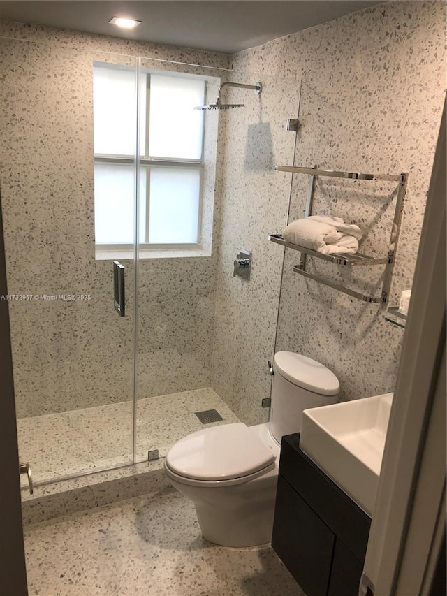 bathroom featuring vanity, an enclosed shower, and toilet