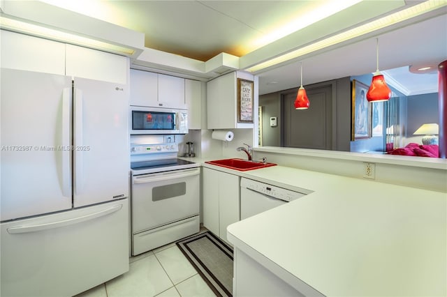 kitchen with white appliances, white cabinets, hanging light fixtures, light countertops, and a sink