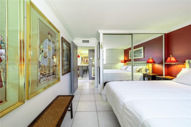 bedroom with light tile patterned floors, visible vents, ornamental molding, and a closet