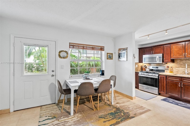 dining space with light tile patterned floors, sink, and a textured ceiling