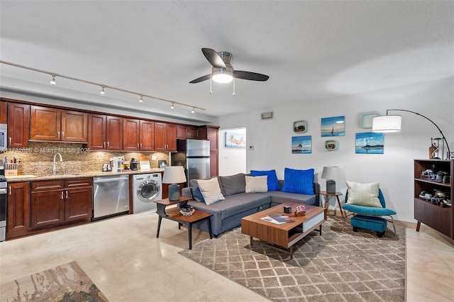 living room featuring washer / clothes dryer, sink, and ceiling fan