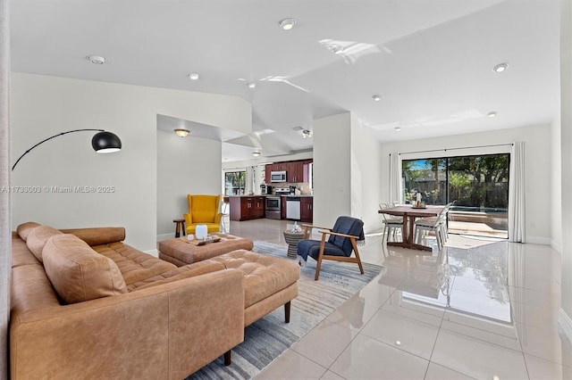 living room with lofted ceiling and light tile patterned floors