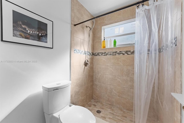 bathroom featuring curtained shower and toilet