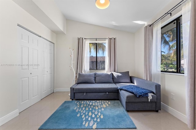 living area with vaulted ceiling and light tile patterned floors