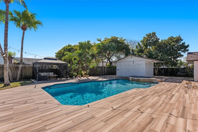 view of swimming pool with a gazebo and an in ground hot tub