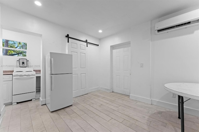 kitchen featuring white appliances, a barn door, light wood-type flooring, and an AC wall unit