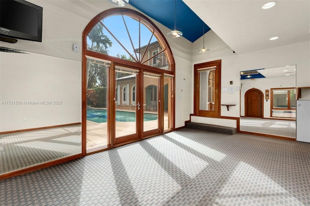 entryway featuring recessed lighting, carpet flooring, a towering ceiling, and baseboards