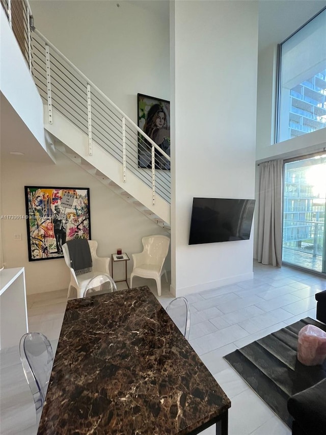 living room with a towering ceiling and light tile patterned floors