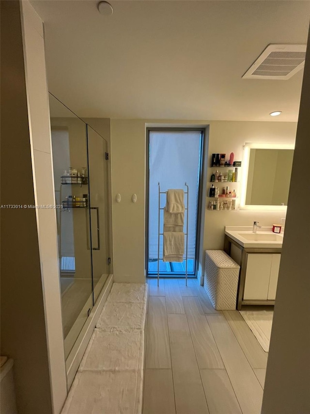 bathroom featuring vanity, an enclosed shower, and hardwood / wood-style floors