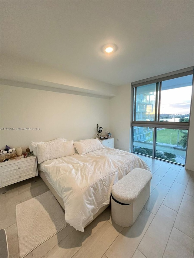 bedroom with access to outside and a wall of windows