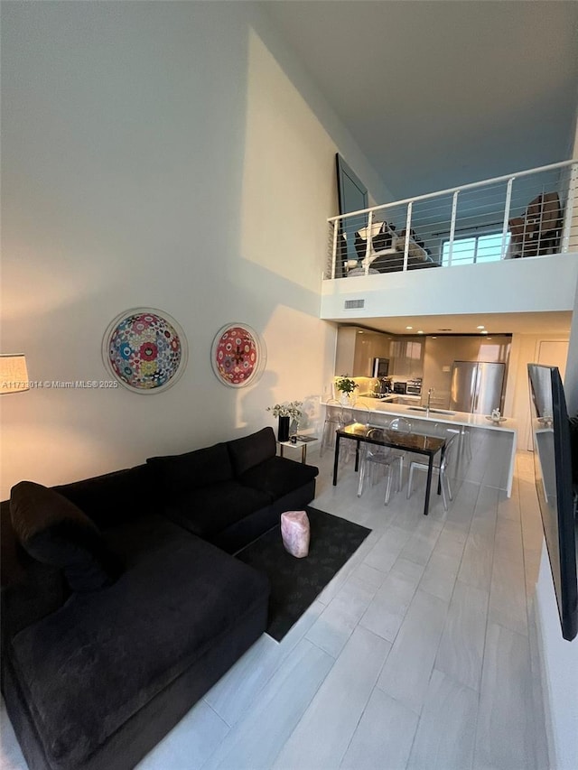 living room featuring sink and a high ceiling