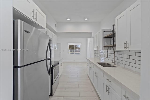 kitchen with white cabinetry, appliances with stainless steel finishes, sink, and tasteful backsplash