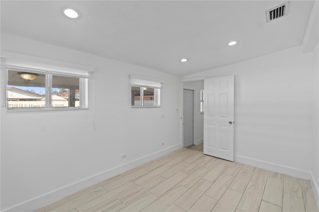 empty room featuring lofted ceiling