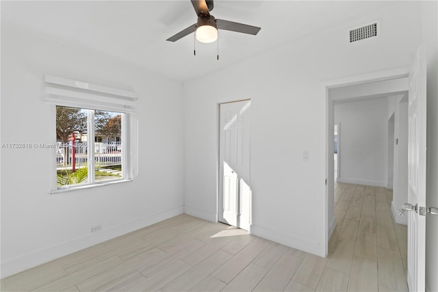 spare room with ceiling fan and light wood-type flooring