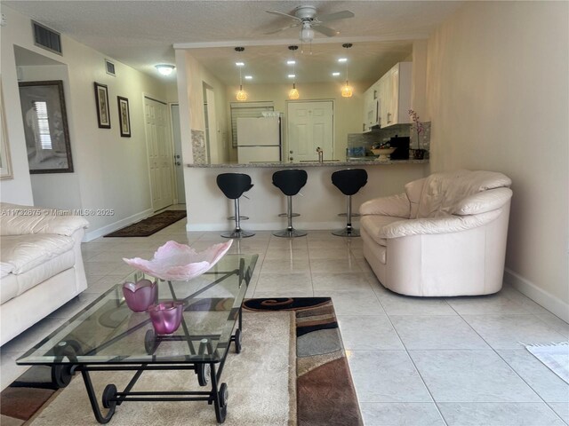 tiled living room with sink and ceiling fan