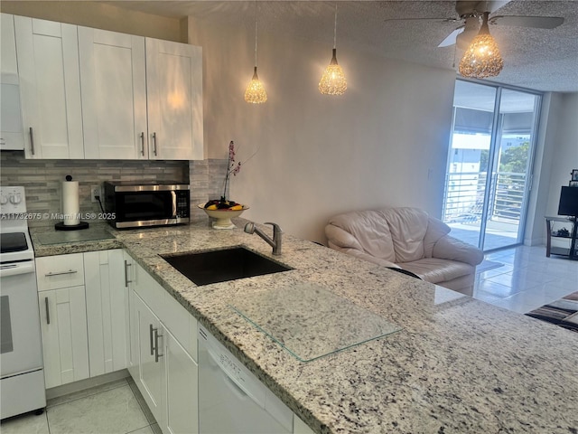 kitchen featuring pendant lighting, decorative backsplash, white appliances, and white cabinetry