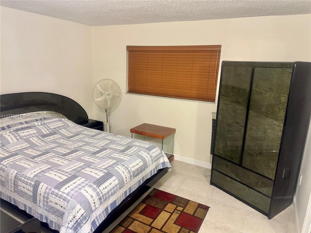 bedroom with light tile patterned floors and a textured ceiling