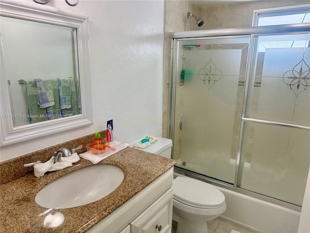 full bathroom with toilet, vanity, bath / shower combo with glass door, and tile patterned flooring