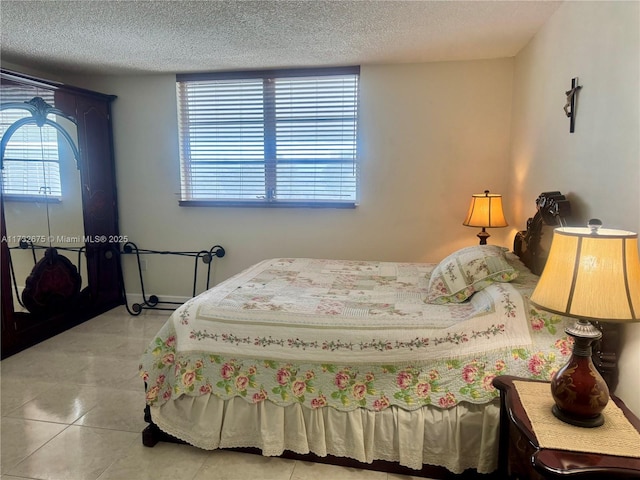 bedroom featuring light tile patterned flooring and a textured ceiling