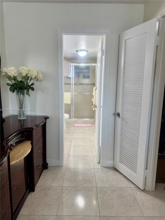 hall with light tile patterned floors