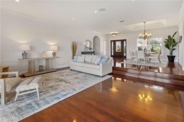 living room featuring a notable chandelier, crown molding, arched walkways, and hardwood / wood-style floors