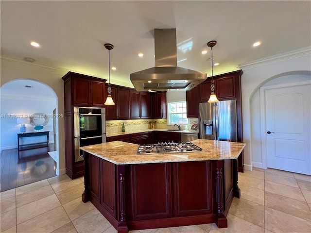 kitchen featuring reddish brown cabinets, arched walkways, appliances with stainless steel finishes, a sink, and island range hood