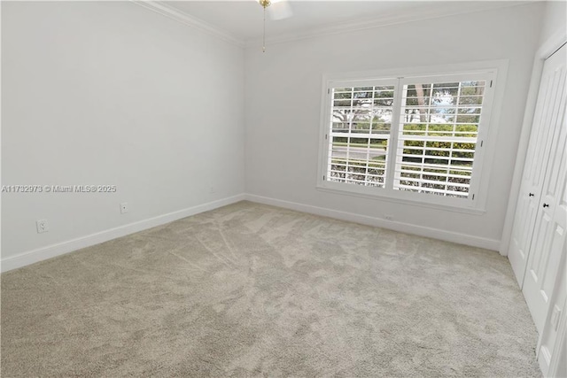 unfurnished room featuring baseboards, carpet flooring, and crown molding