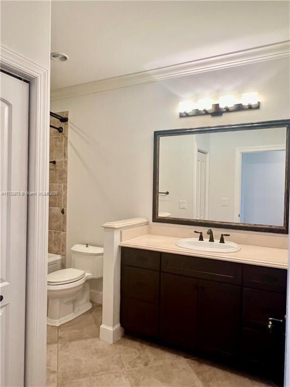 bathroom with crown molding, toilet, vanity, walk in shower, and tile patterned floors