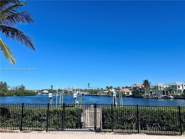 view of water feature with fence, boat lift, and a boat dock