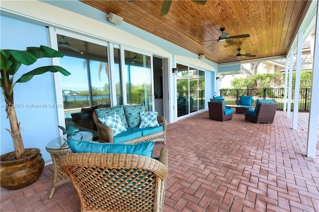 view of patio featuring fence, an outdoor hangout area, and a ceiling fan