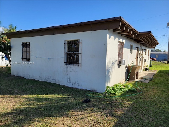 view of side of property with cooling unit and a lawn