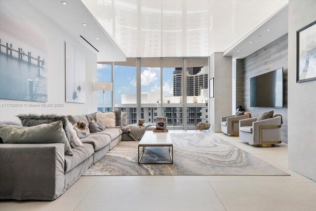 living room featuring light tile patterned floors, expansive windows, and a high ceiling