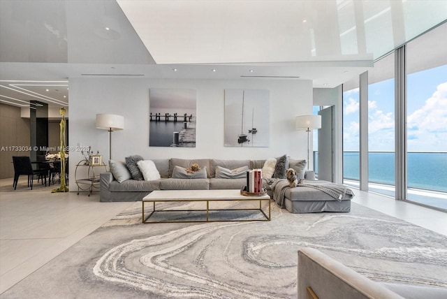 living room with tile patterned flooring, a wall of windows, and a water view