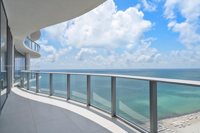 balcony featuring a water view and a beach view