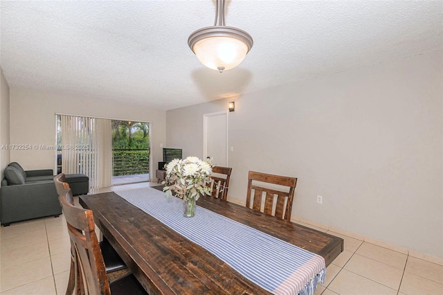 dining space featuring light tile patterned floors and a textured ceiling