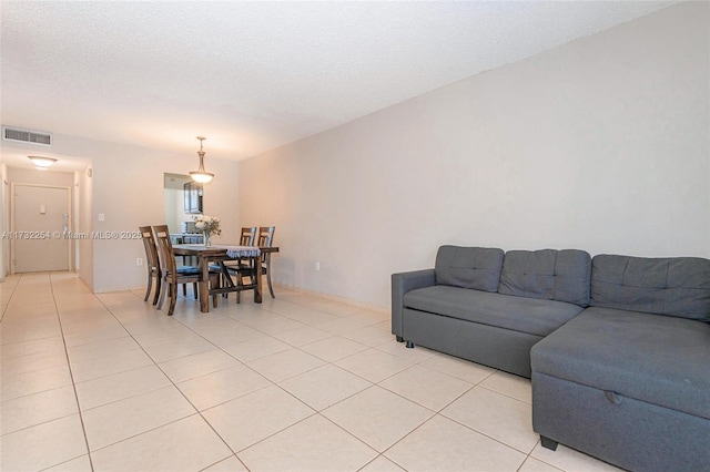 living room with a textured ceiling and light tile patterned floors