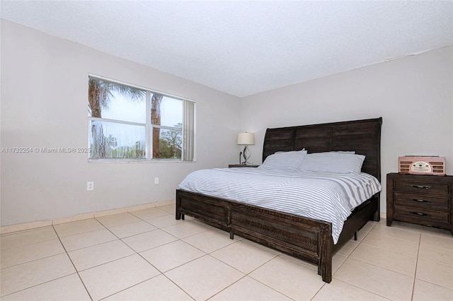 bedroom with light tile patterned flooring and a textured ceiling